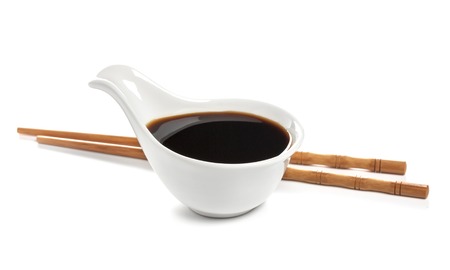 Soy sauce and chopsticks isolated on whiteの写真素材