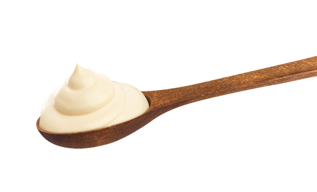 Sour cream in wooden spoon isolated on white backgroundの写真素材