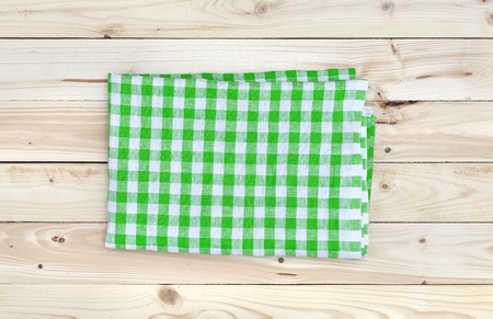 Green tablecloth on wooden table, top viewの写真素材