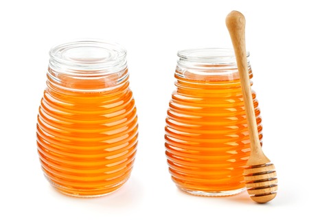 Honey in glass jar isolated on white backgroundの写真素材