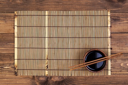 Mat for sushi and chopsticks on wooden background. Top view with copy spaceの写真素材