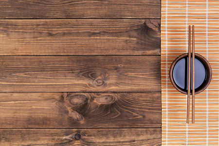 Mat for sushi and chopsticks on dark wooden background. Top view with copy spaceの写真素材