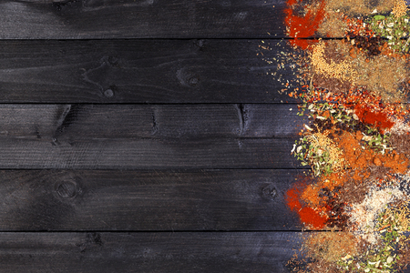 Herbs and spices over black wooden background. Top view with copy spaceの写真素材