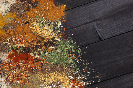 Herbs and spices over black wooden background. Top view with copy spaceの写真素材