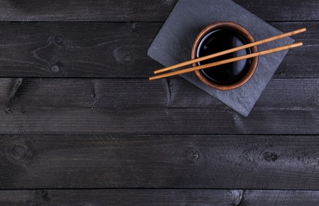 Background for sushi. Soy sauce, chopsticks on black stone. Top view with copy spaceの写真素材