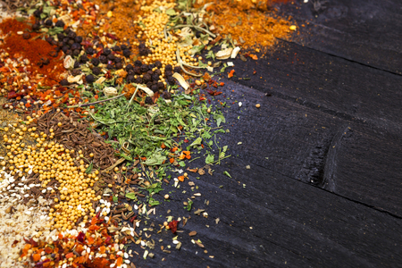 Herbs and spices over black wooden background. Top view with copy spaceの写真素材