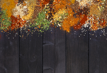 Set of various aromatic colorful spices and herbs on dark wooden background. Space for text. Food frame. Top view with copy space.の写真素材