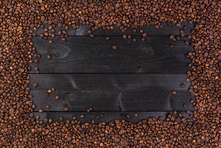 Frame of coffee beans on dark wooden background. Top view with copy spaceの写真素材