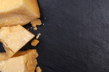 Parmesan cheese on black stone background. Top view, copy space.の写真素材