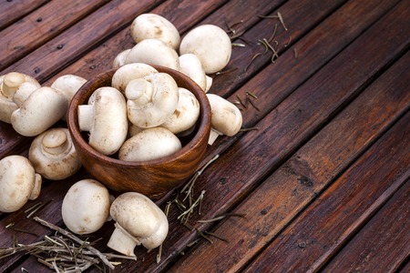 Mushrooms champignon on wooden background. Copy space.の写真素材