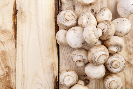 Mushrooms champignon on wooden table. Top view. Copy space.の写真素材