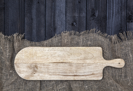 Black wooden table with burlap tablecloth and cutting board, top view, copy spaceの写真素材