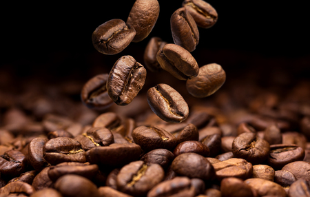 Falling coffee beans. Dark background with copy space, close-upの写真素材