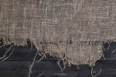 Black wooden table with burlap tablecloth, top view, copy spaceの写真素材