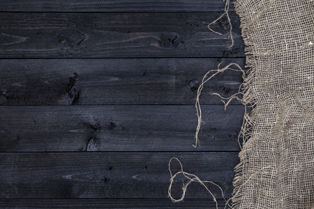 Black wooden table with burlap tablecloth, top view, copy spaceの写真素材
