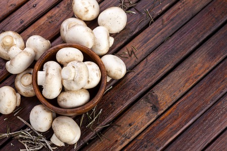 Mushrooms, champignons on wooden background. Top view. Copy space.の写真素材