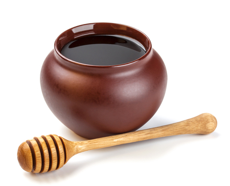Honey pot and honey stick isolated on white backgroundの写真素材
