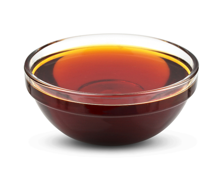 Golden syrup isolated on white background, honey in bowlの写真素材
