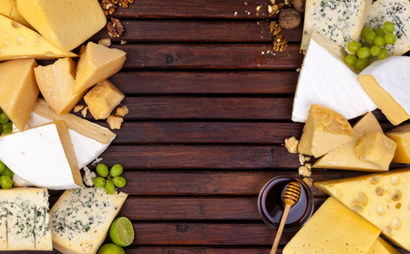 Various cheeses on wooden table with empty space.の写真素材
