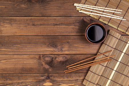 Mat for sushi and chopsticks on wooden background. Top view with copy spaceの写真素材