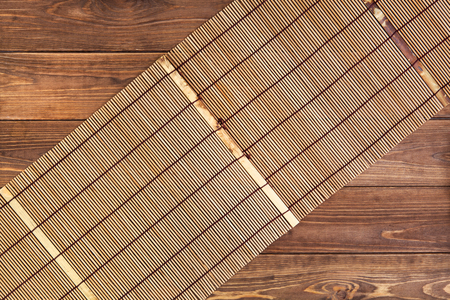 Bamboo mat for sushi on wooden background. Top view with copy spaceの写真素材