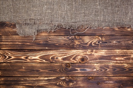 Dark wooden background with burlap, rustic wood and sackの写真素材