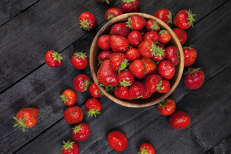 Strawberries on bllack wooden background. Copy space. Top viewの写真素材