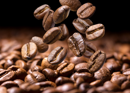 Falling coffee beans. Dark background with copy space, close-upの写真素材
