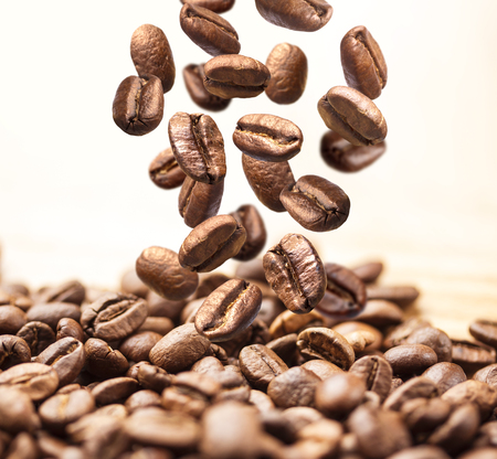Closeup of falling or flying coffee beans on white backgroundの写真素材