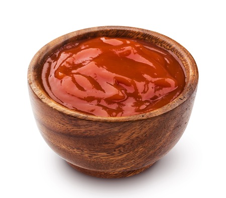 Ketchup in wooden bowl isolated on white backgroundの写真素材