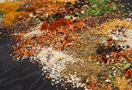 Different herbs and spices on black wooden background. Closeupの写真素材