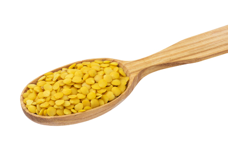 Yellow lentils in wooden spoon isolated on white backgroundの写真素材