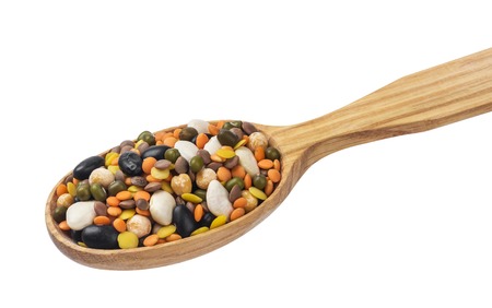 Legumes mix in wooden spoon isolated on white background. Mixed black and white kidney beans, green mung, different lentils, chickpeas, peas.の写真素材
