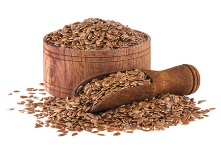 Flax seeds in wooden scoop and bowl isolated on white background close upの写真素材