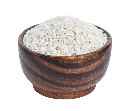 Risotto rice in wooden bowl isolated on white backgroundの写真素材