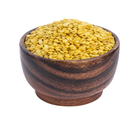 Yellow lentils in wooden bowl isolated on white backgroundの写真素材