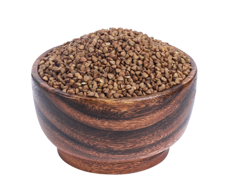 Buckwheat groats in wooden bowl isolated on white backgroundの写真素材