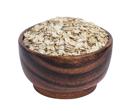 Isolated oatmeal. Oat flakes in wooden bowl on white backgroundの写真素材