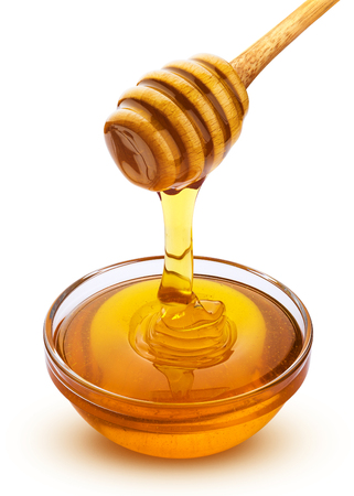 Honey stick and bowl of pouring honey isolated on white background with clipping pathの写真素材