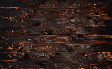 Burnt wooden board, black charcoal wood texture, burned coal barbecue background with copy space, top viewの写真素材