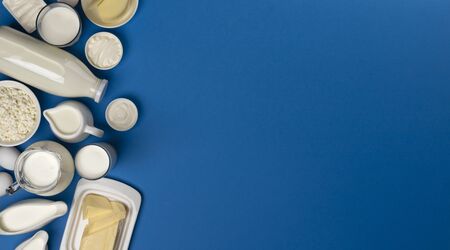Set of dairy products on blue wooden background, assortment of milk, cottage cheese, sour cream and yogurt, top view with copy spaceの写真素材