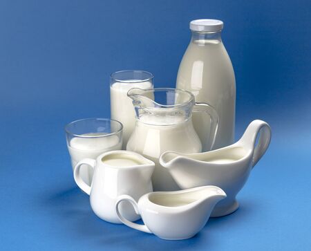 Set of dairy products on blue wooden background, assortment of milk, kefir, sour cream and yogurt with copy spaceの写真素材