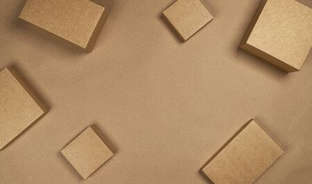 Blank brown cardboard boxes on craft paper background, top view with copy space, product package...