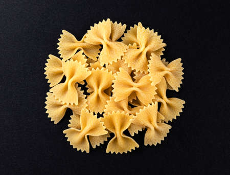 Pile of raw farfalle pasta isolated on black background, top viewの写真素材
