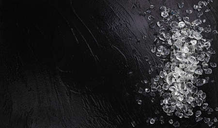 Pile of crushed ice cubes on black stone background, top view with copy spaceの写真素材