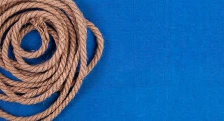 Twisted rope on blue canvas background, top view with copy space