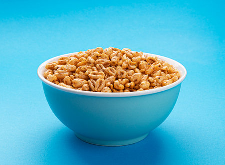 Puffed wheat cereal isolated on blue background