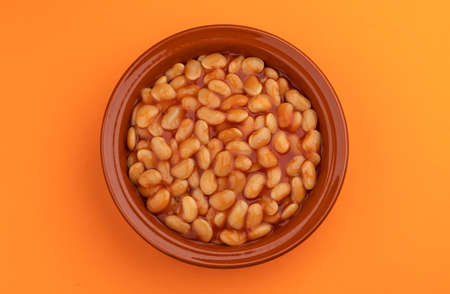 Clay rustic plate of baked beans in tomato sauce with copy space, top viewの写真素材