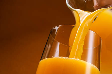 Orange juice pouring into glassの写真素材