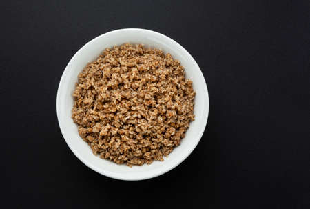 Bowl of buckwheat flakes on black backgroundの写真素材